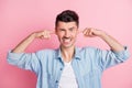 Photo of angry irritated unhappy guy close fingers ears loud noise isolated on pink color background Royalty Free Stock Photo