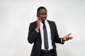 Closeup of angry young african man screaming while talking on smartphone over grey background Royalty Free Stock Photo