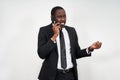 Closeup of angry young african man screaming while talking on smartphone over grey background Royalty Free Stock Photo