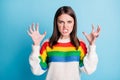 Photo of annoyed angry young woman dressed striped sweater showing teeth rising arms isolated blue color background