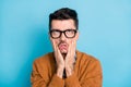 Photo of annoyed tired man hold palms cheekbones look up wear glasses isolated on blue color background