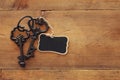 photo of antique key and empty blackboard tag over old wooden table. Royalty Free Stock Photo