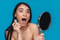 Shocked young woman apply lash mascara holding mirror Royalty Free Stock Photo