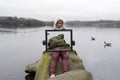 Asian Woman Holding Picture Frame With Lake & Rocks Trick Photography. Royalty Free Stock Photo