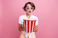 Photo of astonished girl dressed white shirt in 3d glasses eat popcorn staring at interesting movie isolated on pink Royalty Free Stock Photo