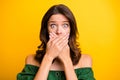 Photo of astonished guilty young woman tell secret mistake cover mouth hands on yellow color background