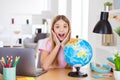 Photo of astonished kid girl study geography remote impressed new continent information scream touch hands face sit