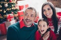 Photo of astonished little girl parents look interested unbelievable reaction newyear tree lights decor flat indoors Royalty Free Stock Photo