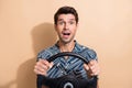 Photo of astonished man with stylish hair dressed print shirt hold streering wheel staring at accident isolated on beige Royalty Free Stock Photo