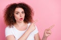 Photo of astonished woman with perming coiffure dressed white t-shirt directing at discount empty space isolated on pink Royalty Free Stock Photo