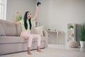 Photo of astonished young lady sit couch raise hands hold gamepad open mouth barefoot wear green t-shirt pink trousers