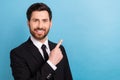 Photo of attractive businessman wear black suit with necktie point finger empty space enjoy terms work isolated on blue