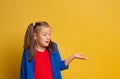 Photo attractive caucasian cute girl impressed astonished gesture hand wear red t-shirt and blu jacket on yellow background