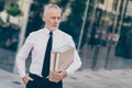 Photo of attractive confident mature worker man wear formal shirt walking holding paper folders outdoors city street Royalty Free Stock Photo