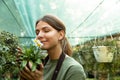 Photo of attractive cute woman gardener smelling plant