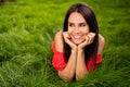 Photo of attractive dreamy stunning brunette woman hold hands cheeks lie grass look park outside in outdoors