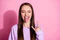 Photo of attractive funky cool youngster lady protrude tongue mouth show finger horns crazy rock music lover concert