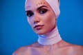 Photo of attractive girl patient in medical bandage have examination before plastic surgery over blue background