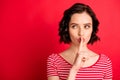 Photo of attractive girl trying to set silence in order to think over her plans while isolated with red background with
