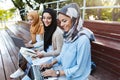 Photo of attractive islamic women wearing headscarfs resting in green park Royalty Free Stock Photo