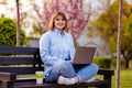 Photo of attractive lady student sit on bench in green park browsing notebook chatting friends do home tasks inspiration nature Royalty Free Stock Photo