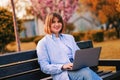 Photo of attractive lady student sit on bench in green park browsing notebook chatting friends do home tasks inspiration nature Royalty Free Stock Photo