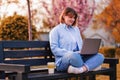 Photo of attractive lady student sit on bench in green park browsing notebook chatting friends do home tasks inspiration nature Royalty Free Stock Photo