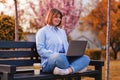 Photo of attractive lady student sit on bench in green park browsing notebook chatting friends do home tasks inspiration nature Royalty Free Stock Photo