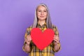 Photo of attractive senior woman hold red paper heart cupid romantic isolated over purple color background