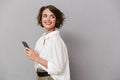Photo of attractive woman 20s smiling and holding mobile phone