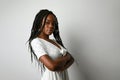 Profile photo of young African woman with long braids posing over white wall. Royalty Free Stock Photo