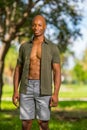 Photo attractive young bald black man smiling at camera. African American male model enjoying holiday in the park Royalty Free Stock Photo