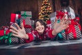 Photo of attractive young woman lying floor stretch hands funky dressed red sweater christmas room interior design tree Royalty Free Stock Photo