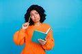 Photo of attractive young woman notepad look confused empty space wear trendy knitwear orange clothes isolated on blue Royalty Free Stock Photo