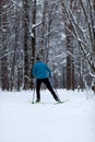 Photo from back of athlete skier in forest at winter