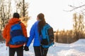 Photo from back of man and woman with backpacks in winter Royalty Free Stock Photo