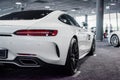 Photo of the back of modern white colored beautiful car parked indoors