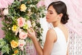 Photo from back of young brunette in white dress on background of flowers Royalty Free Stock Photo