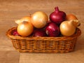 Photo of a Basket of Fresh Organic Whole Onions - yellow / white and loose red onions. Royalty Free Stock Photo