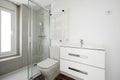 Photo of a bathroom with a bench sink cabinet, a white towel warmer wall radiator