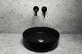 Photo of bathroom details: black round washbasin and mounted tap. Royalty Free Stock Photo