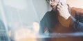 Photo bearded adult hipster working on modern urban cafe. Man wearing black shirt and speaking contemporary smartphone. Wide, film