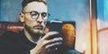 Photo bearded businessman relaxing modern loft office. Banker sitting in vintage chair, looking mobile phone. Using Royalty Free Stock Photo