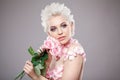 Photo of a beautiful blond woman with flower. Closeup attractive sensual face of white woman with curly hair. Smokey eye Royalty Free Stock Photo