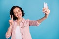 Photo of beautiful cheerful cool lady hold telephone making selfies showing v-sign symbol popular blogger wear casual