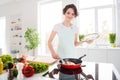 Photo of beautiful cheerful housewife lady put fresh raw salmon fillet steak on flying pan keeping diet cooking hobby