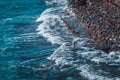 Photo of beautiful clear turquoise sea ocean water surface with ripples and bright splash on stone seascape background Royalty Free Stock Photo