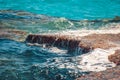 Photo of beautiful clear turquoise sea ocean water surface with ripples and bright splash on stone seascape background Royalty Free Stock Photo