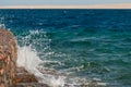 Photo of beautiful clear turquoise sea ocean water surface with ripples and bright splash on stone seascape background Royalty Free Stock Photo