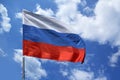 Photo of the beautiful colored national flag of the modern state of Russia waving against a blue sky, textured fabric, concept of Royalty Free Stock Photo